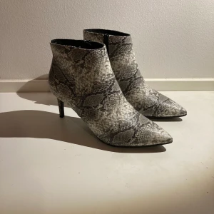 Ormskinnsboots strl 40 - Oanvända snakeprint boots. Finns i Sthlm. Kan mötas upp alt skicka! Mottagaren betalar frakt. 