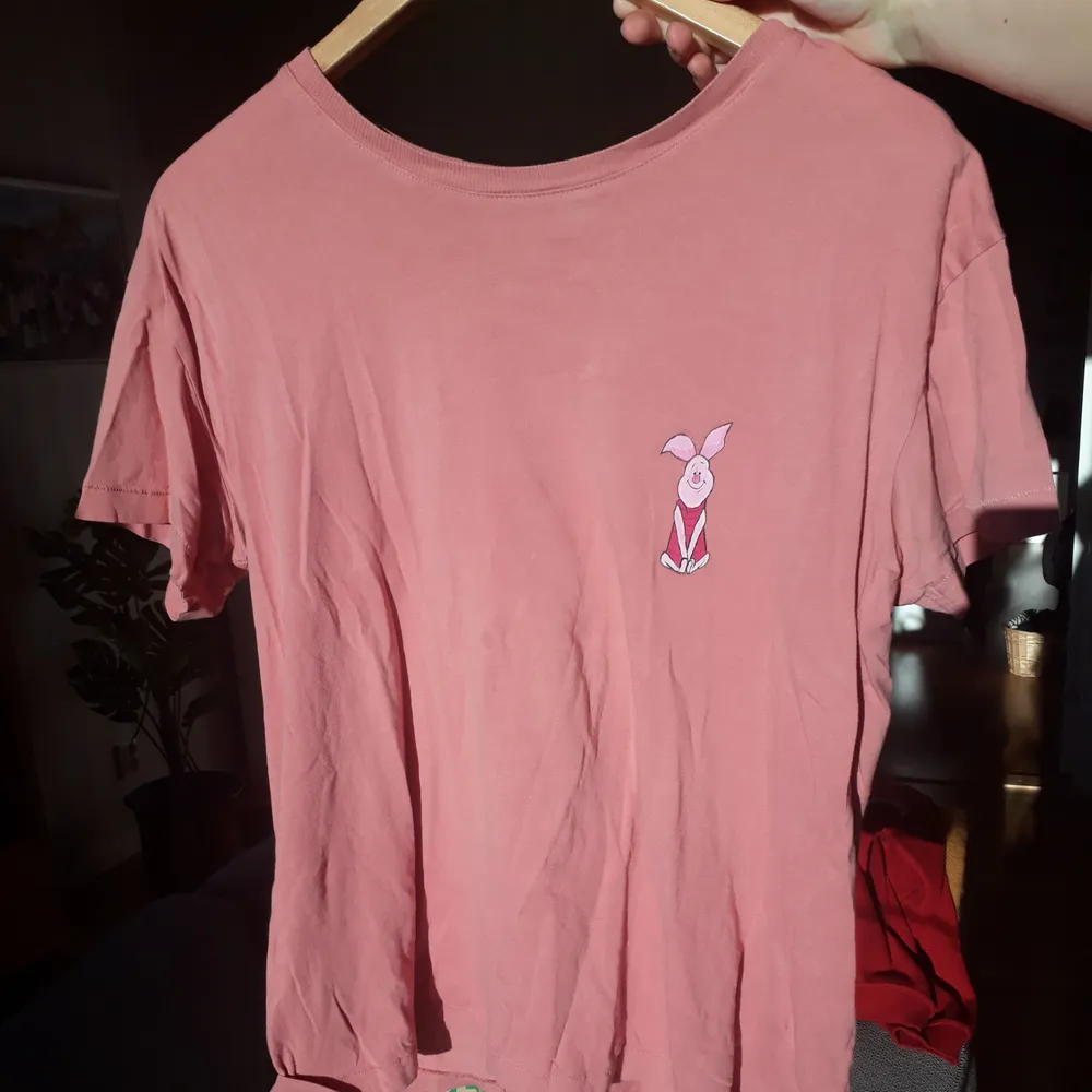 En rosa t-shirt med nasse från nalle puh på i tunnare material. Jag har målat den själv. Går att tvätta i 40°c. T-shirts.