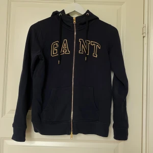 Gant tröja strl xs - En marinblå tjocktröja med dragkedja från Gant, köpt i en av Gants butiker. Tröjan är använd få antal gånger och är i gott skick!😀 (kan mötas upp i Örebro eller så betalar köparen för frakten.)