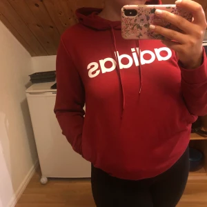 Röd Adidas Hoodie  - Fick i present men föll mig inte i smaken så den testades bara ocj därför säljer jag den nu. Syns någorlunda på bild men den har fickor på bägge sidorna. 