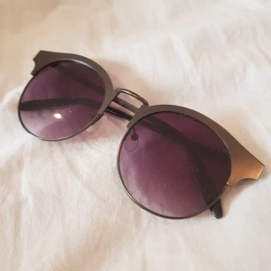  - Jättefina solglasögon med metallpinnar och lilasvart tonat glas! Lite glappa på ena pinnen men det går att dra åt med skruvmejsel! Frakt - 20 kr 