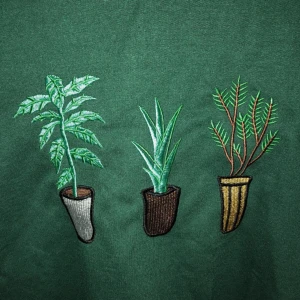  - Grön sweatshirt med växter på. Köpt på second hand så både märket och storleken är oklart men passar S/M