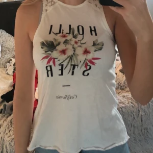 Linne från Hollister - Ett mycket fint vitt linne ifrån Hollister, spetsdetaljer och tryck på framsidan. Använd fåtal gånger. 50 kr + 45 kr frakt ❄️