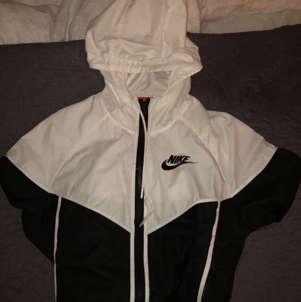 En windbreaker jacka ifrån Nike i svart och vit. Storlek S, det är endast snöret som är lite sönder, vilket man kan fixa, annars är den i bra skick. Pris kan diskuteras!. Jackor.