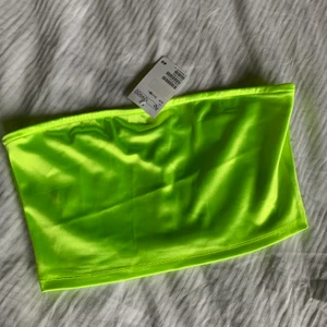 Bandeau topp i neon  - En fin bandeau topp i gul neon, aldrig använd- prislapp kvar! Jag köpte den på HM på Bali för ca ett år sen men har aldrig kommit till användning! 