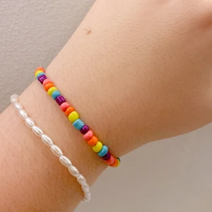 Färgglatt pärlarmband  - Ett färgglatt armband gjord på elastisk tråd med glaspärlor. Frakt är inkluderat i priset.