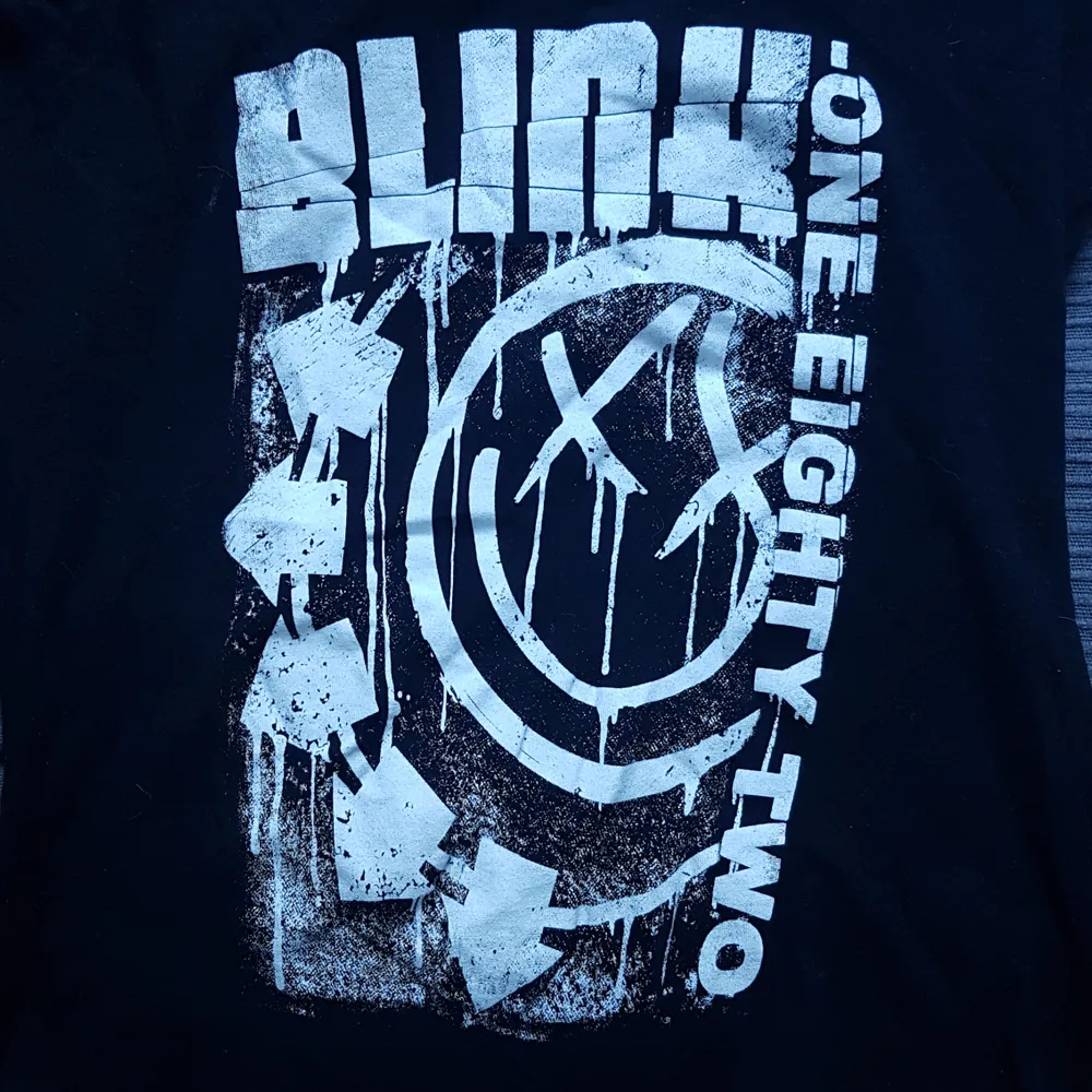 Blink-182 t-shit med hål i ryggen, syns på bild två. Har ett vitt papper så hålen ska synas bättre, tröjan är bara svart med vitt tryck! Den är använd en gång då jag ej var bekväm i den så priset är diskuterbart!. Skjortor.