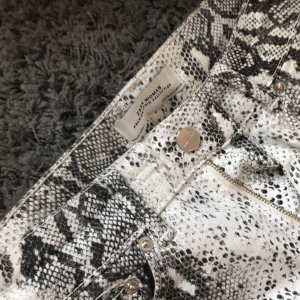 Ormjeans från zara - Säljer dessa coola jeans med ormmönster från zara. Det är högmidjade och utsvängda nertill. Använt de 1 gång bara så de är så gott som nya i mycket bra skick. Hör av er om ni vill ha fler bilder osv. Köpta för 400kr. Köparen står för frakten✨💗💜