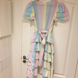  - Retro klänning i pastellfärger. Passar Strl 38/40. Passar bra till både fest som 80-talsutklädnad. Köparen står för frakten.