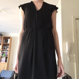  - Den lilla svarta med holkärm, knappar och fina veck fram och snöre att knyta i midjan. Material: polyester 

Jag skickar med posten eller möter upp i Stockholm. Betalning via Plick, kontoinbetalning, kontant eller swish.