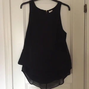  - Svart linne från H&M som fungerar bra så väl till vardags som vid finare tillställningar. 100% polyester med längre undertyg bak.