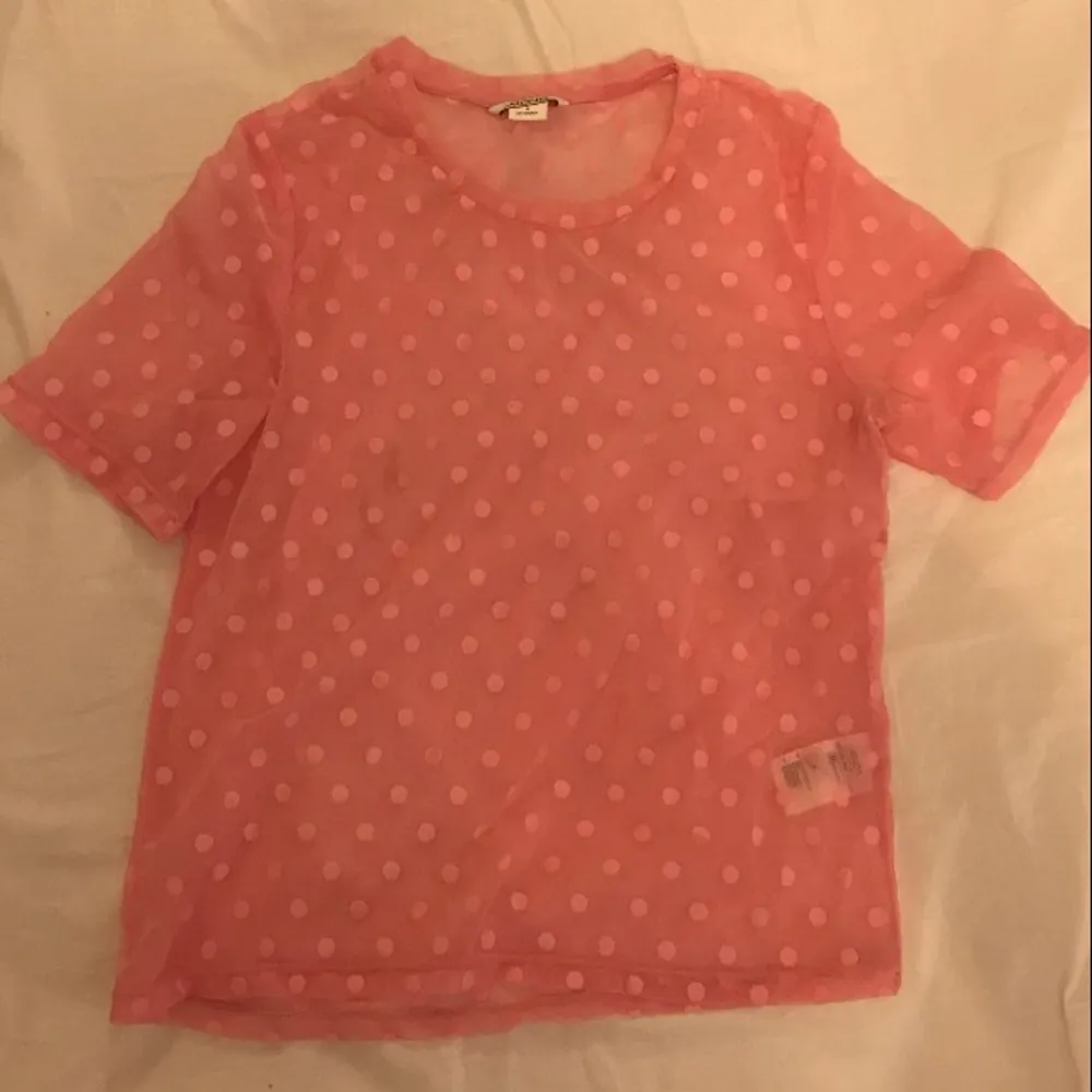 rosa genomskinlig t-shirt med prickar. köpt från monki. i gott skick. . Toppar.