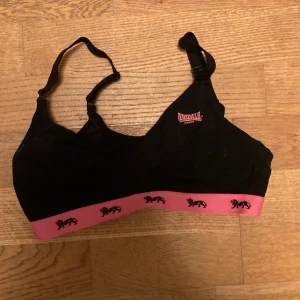 Svart sportbh med rosa detaljer i storlek 34b - Svart sportbh med rosa detaljer i storlek 34b