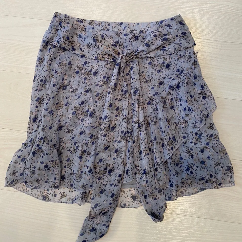 Floral miniskirt from Neo Noir. Soft sheer material with a hint of glitter in it. There’s a fabric underneath making it not see through. Color is a light blue/purple. The skirt ties in the front and has an elastic waistband, therefore it’s quite adjustable and would fit sizes XS-M. Used 3-4 times, but in perfect condition!💜 . Kjolar.