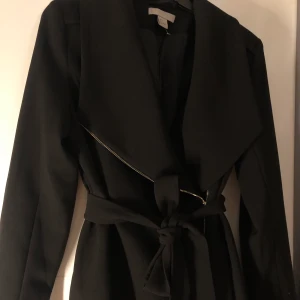 Svart blazer aktig jacka - En jacka med jätte fina gulddetaljer, perfekt för vår/höst. Köpt från H&M. Använd flera gånger dock helt felfri. 