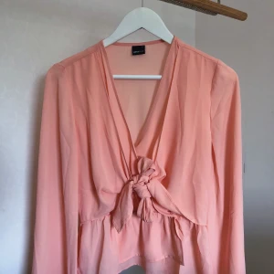 Ljus rosa blus - En jätte fin ljus rosa blus med en fin rosett knytning på framsidan. Använd 1 gång. 💗