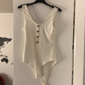 Fin vit body med bruka knappar - Vit body från hm, använd en gång som ny. Möts i Karlstad eller skickas ( du står för frakten) 