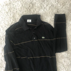 Långärmad med krage  - Lacoste tröja. Svart med gul beigea ränder. Bra skick. 