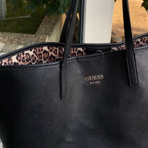 Guess väska - Säljer min GUESS Handväska 'Vikky' i Svart som är leopardmönstrad på insidan. Ordinarepris 1800kr. Den är använd fåtal gånger o det finns inga skador på väskan. Köpare står för frakt🥰 pris kan diskuteras🌻🥰