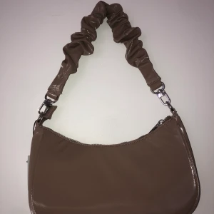 Axelväska  - En snygg axelväska jag köpte som jag sedan insåg att jag inte kommer att använda. Hostig snygg färg & även helt ny, aldrig använd & lappen e kvar. Frakt står du för själv! 