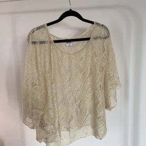 Spetstopp - Fin beige topp i spetsmaterial och oversize passform. Storlek S/M och i nyskick.