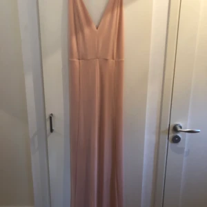 Rosa långklänning - Aldrig använd slim rosa långklänning med fin rygg. Ordinarie pris 300kr. Buda i kommentarerna så skriver jag privat till den med bäst pris. Leverans om i närheten men om frakt betalar köparen. 