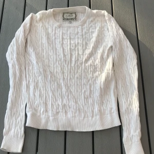 Kabelstickad tröja i storlek ca XS - En jättefin kabelstickad tröja i storlek 158,164 ca XS. Jag kommer ej ihåg vart den är ifrån. Men den har används några gånger men är ändå i fint skick. (Frakten ingår i priset)