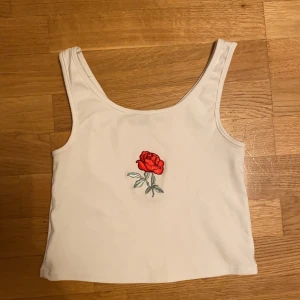 Linne med ros - Linne med en ros på, är i bra skick, inga hål eller liknande. Väldigt stretchig. 70 kr + frakt. Frakten ligger på 22 kr.