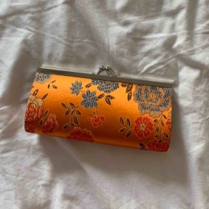  - En orangeblommig portmonnä, aldrig använd❤️ köparen står för frakt. Budgivning!❤️