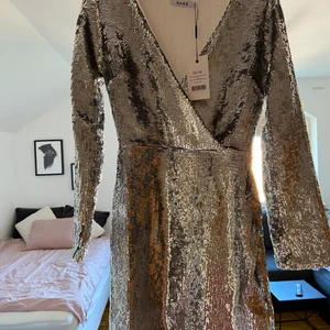 Oanvänd festklänning - Helt oanvänd silvrig paljettklänning från Na-Kd! Bekväm och bra passform, säljer pga returtiden gick ut! Ord pris 599kr, köparen står för frakt 