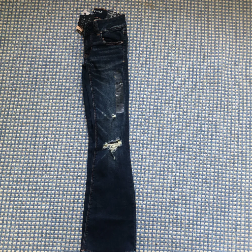 Mörkblåa slitna American Eagle jeans Flare och super stretch,  aldrig använda med lappen kvar!  . Jeans & Byxor.