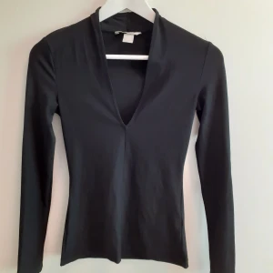 Svart topp - Svart topp i ett tunt och fint material. Går upp lite högre i nacken med en fin urringning fram. Tight passform. 80 kr, frakt ingår🌸