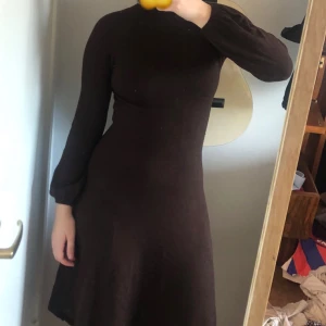 tight vintage klänning - brun knälång klänning köpt på second hand. Puffiga ärmar vid vristen och väldigt hög krage. Storlek S men stretchigt material så passar M också. Knälång, tight upptill men kjolen är utsvängd. Finfint skick, säljs bara för att den inte används längre! 