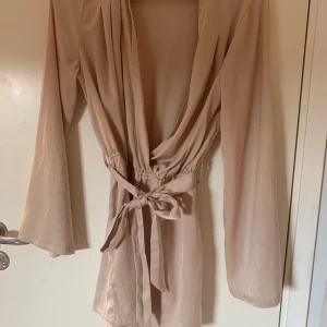 Byxdress från NAKD - Säljer min byxdress från Hanna Licious kollektion med NAKD. Den är i ett beiget lite silkes-material med lite större ärmar. Passar perfekt till alla tillfällen. Frakt ingår!💜