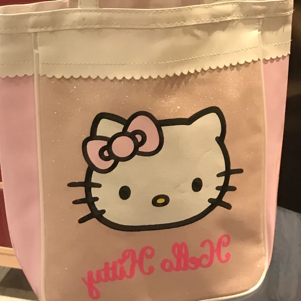 Glittrig hello Kitty väska i plast. Korta handtag. . Väskor.