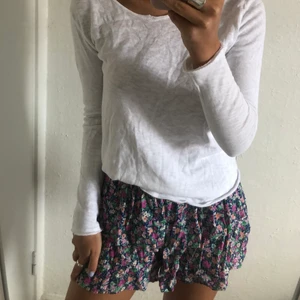 Färgglad kjol/shorts - Kjol med med färgglatt blommigt mönster. De har shorts inanför volangerna.