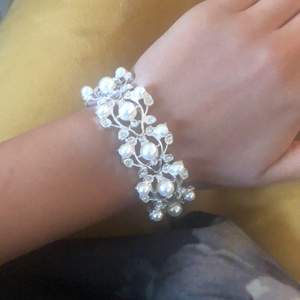 Väldigt sött silverfärgat armband med blommigt mönster.