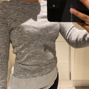 Tröja med layer imitation - Tröja med detalj som imiterar ett skjort lager under. Tröjan är helt ny och har aldrig använts sedan den köptes förra året. 