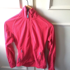  - Snygg rosa Tjocktröja som kommer från märket FUNK med polokrage och fickor på vadera sida beskrivs som storlek S
