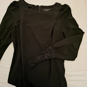  - Svart tunnare långärmad tröja från Sisters. Spets längst ut på armarna. 