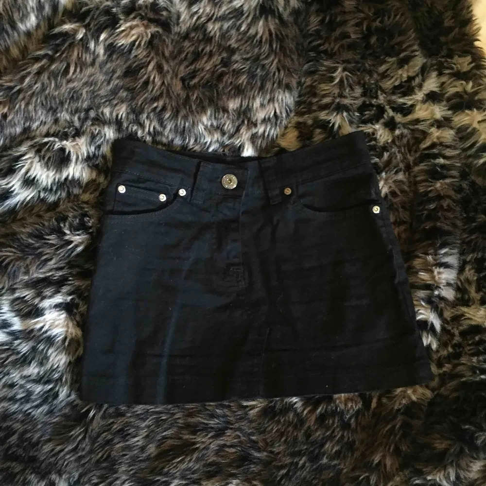 Supercool svart minikjol i jeansmaterial, med ballaste trycket där bak! Tyvärr för liten för mig. Aldrig använd men köpt för många år sen så tvivlar på att den går att få tag på ny.. Kjolar.