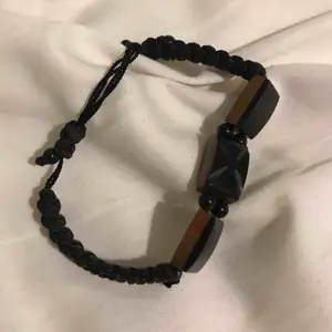 Black bracelet, plastic and durable thread. Almost new. Bought in the US.
