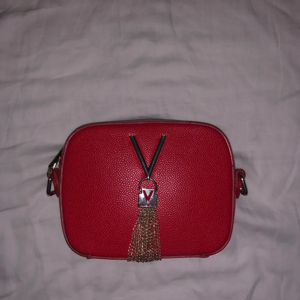 En röd valentino väska som köptes i Italien. Har inga hål eller fläckar, men säljs utan band. Säljs för att den inte kommer till användning. . Väskor.