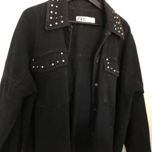 Jeansjacka från Zara  - Cool svart jeansjacka från Zara med detaljer! Jag har klippt den på baksidan så den inte är så lång, men annars i väldigt bra skick. Frakt tillkommer 