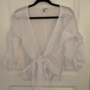 Vit blus  - Super söt knyt topp/blus med puff ärm ifrån Nelly. Använd få gånger, är i fint skick! 