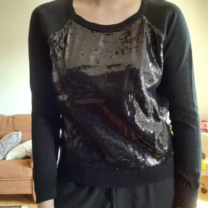 Svart glitter tröja - Svart tröja med svarta paljetter. Alla paljetter sitter kvar och tröjan är tunn så den är inte varm. På andra bilden ser man att den inte är helt täckt av paljetter. Storlek XS och därav liten på mig i bilden. 70 exklusive frakt