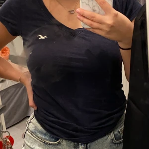 Marinblå t-shirt - En marinblå t-shirt ifrån hollister med märket på bröstet, den är använd några gånger och är i storlek XS. Väldig fin skurning över bröstet.