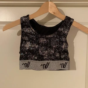 Varisty sport-bh - Fin, glittrig sport-bh från Varsity. Oanvänd, ord. Pris ca. 300kr. Storlek 34/S. Kan mötas upp i Västerås, annars står köparen för frakten.