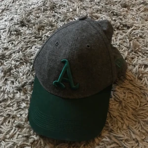 Grön&grå keps  - En grön&grå keps i one size. Kommer inte ihåg vart den är köpt tyvärr men den är i bra skick.             40kr + frakt 😊