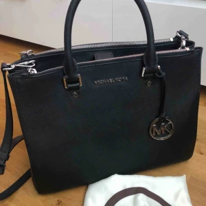  - Jag säljer nu min Michael Kors väska med silvriga detaljer eftersom den aldrig används. Dust bag medföljer.   33x26x14  Använd men i väldigt fint skick. Köpare står för ev f rakt